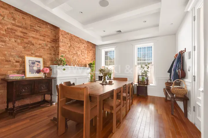 Living / dining room, looking toward the front windows along the brick wall